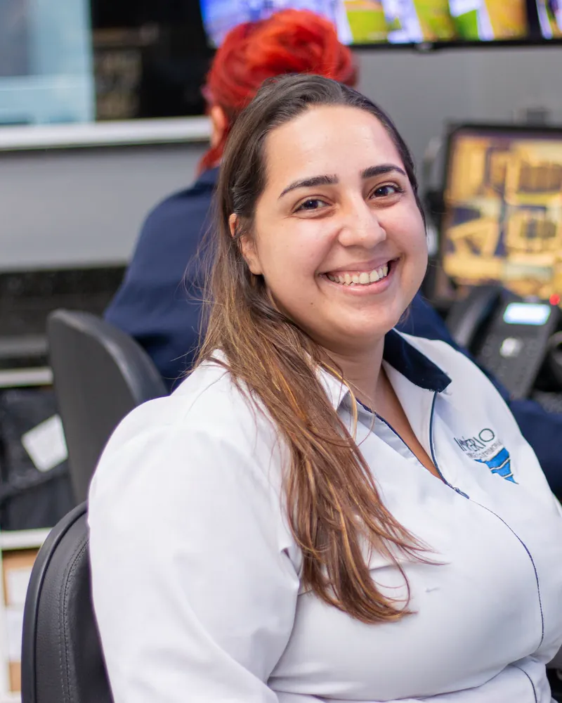 Colaboradora da Império sorrindo na central de monitoramento